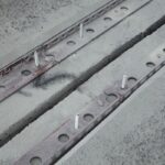 Metalowe profile dylatacyjne z kotwami zamocowane po obu stronach szczeliny w betonowej posadzce