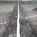 Uszkodzony pas rozdziału na autostradzie z odsłoniętymi prętami zbrojeniowymi i gruzem po wypadku lub pożarze
