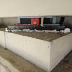 Betonowa podstawa konstrukcyjna z metalowym wspornikiem i pianką uszczelniającą w trakcie montażu