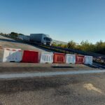 Zamknięty pas autostrady z biało-czerwonymi barierami na moście, w oddali jadąca ciężarówka