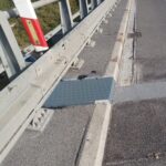 Bariera ochronna na moście z metalową płytą przy krawężniku i jezdnią po prawej stronie
