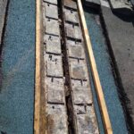 Odsłonięty fragment płaskiego dachu z drewnianą konstrukcją i niebieską warstwą izolacji podczas naprawy